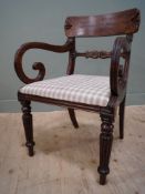 A William IV mahogany library armchair, curved back over carved splat and scrolled arms with