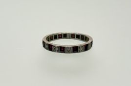 A white metal eternity ring set twelve old mine cut diamond points and twelve cushion cut rubies