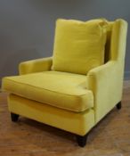 A contemporary wingback armchair, upholstered in stylish yellow velvet fabric with loose back and