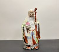 A Chinese porcelain figure of 'Shou Lao', the God of longevity, the figure modelled holding a