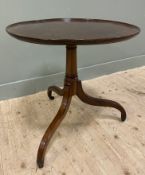 An Edwardan mahogany tilt-top occasional table, circular top with moulded edge, raised on baluster-