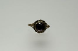 An Edwardian 9ct gold foil set cabochon garnet a/f within a pierced border P/Q 2.78g