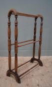 An Edwardian solid oak six-bar towel rail, arched sides on shaped turned supports united by rails on