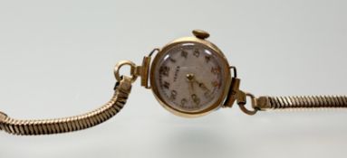 A 9ct gold Vertex wristwatch with cream enamel dial and roman numerals on gilt snake link adjustable
