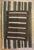 A vintage Turkish kilim rug, composed of repeating brown and sand coloured stripes (a/f some holes