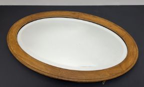 An early 20thC oval wooden framed mirror with faceted mirror plate and hanging chain verso (l. 70cm)