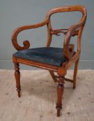 A 19thc mahogany library armchair, arched top over a carved splat to back with scrolled arms, blue