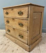 An early 20th century pine chest of drawers, fitted three graduated long drawers with brass drop