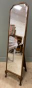 A 1920s/ 30s oak-framed floor-standing mirror, bevelled plate enclosed within a shaped frame on
