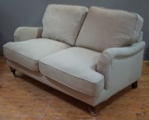A contemporary country house two-seater sofa, with down back and seat cushions and rolled arms,