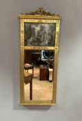 An Edwardian trumeau gilt mirror with ribbon floral mount and central printed panel depicting a
