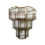 A large contemporary chandelier, in brushed metal finish with three graduated tiers of curved