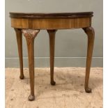 A 1930s George II-style burr walnut card table, with semi-circular cross-banded top opening to