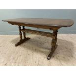 A modern elm extendable dining table by Ercol, rectangular top with curved edges, on sliding