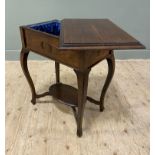 An Edwardian oak sewing table, rectangular mould top pivoting to reveal lined interior, raised on