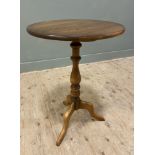A modern elm tripod table, by Ercol, circular top raised on baluster support with tripod base: H.