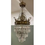 An Edwardian French style cut glass and brass waterfall chandelier, with a campus leaf detail to