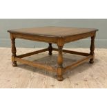 A mid-century elm coffee table, by Ercol. Square top with rounded edges raised on baluster