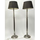 A pair of nickel table lamps in the form of candlesticks, raised on circular bases with brown