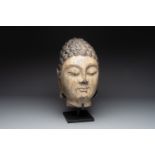 A large Chinese carved stone head of Buddha with traces of gilding and polychromy, Ming