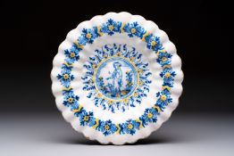 A polychrome lobed Dutch Delft 'Compendario' dish with a shepherd with his dog, 17th C.