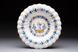 A polychrome lobed Dutch Delftware dish with a putto smoking a pipe, probably Verstraeten workshop,