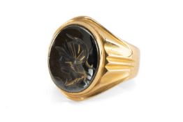 YELLOW METAL HEMATITE SIGNET RING, the oval hematite with intaglio Roman Centurion design, ring size