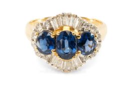 18CT GOLD SAPPHIRE & DIAMOND CLUSTER RING, the three oval-cut sapphires within border of round-cut