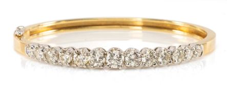 18CT GOLD DIAMOND HINGED BANGLE, 13 stones graduated from 0.2 to 0.5ct, 26.5g Provenance: private