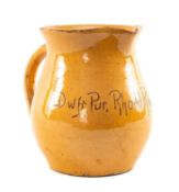 EWENNY SLIPWARE POTTERY JUG with single handle, orange glaze over red earthenware body, inscribed