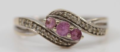 A 9ct white gold pink sapphire and diamond cross over ring, O 1/2, 2.5g