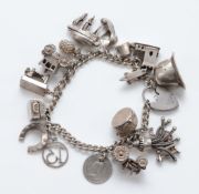 A silver charm bracelet, with a Georg Jensen heart shaped padlock clasp and sixteen charms, 67g