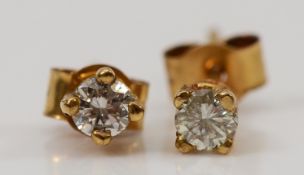 A pair of 9ct gold brilliant cut diamond earrings with scroll backs, 0.4g