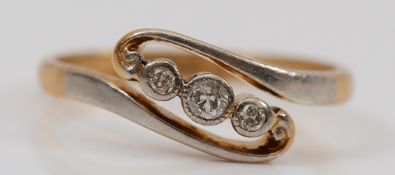 An 18ct gold and platinum brilliant cut diamond three stone ring, L 1/2, 2.6g
