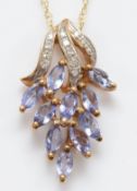 A 9ct gold tanzanite and diamond cluster pendant on a chain, 2.5g