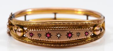 An Edwardian 9ct gold soude ruby and rose cut diamond hinged bangle, with safety chain, 58mm,