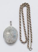 A silver engraved locket pendant with a silver chain, Birmingham 1978, 20g