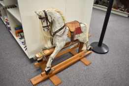 A traditional style Rocking Horse having horse hair mane and tail, leather saddle on swing action
