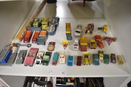 A shelf of Dinky, Corgi, Matchbox and similar playworn Die-casts including Dinky Rear Dump Truck,
