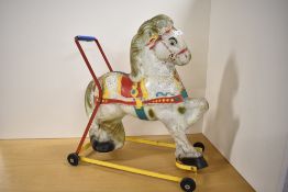 A mid 20th century tin plate push along Horse on metal frame, height 5cm, length 50cm