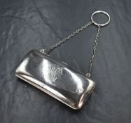 An Edwardian silver purse, of rectangular form having engraved monogram to the front and chain