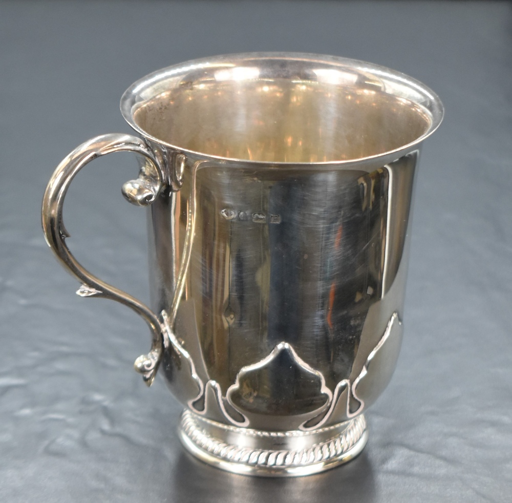 A George V silver tankard, of traditional form having a flared rim, decorative s-scroll handle and