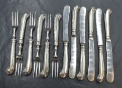 A cased set of six George V silver handled cake knives and forks, having scroll decoration to the