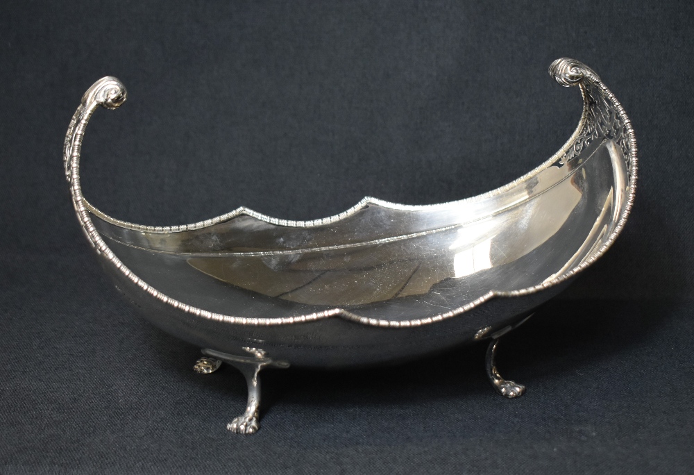 An impressive George V silver bowl, of long boat form having an egg and dart rim with scroll