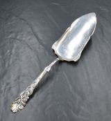 A cased Danish silver cake server, having raised scroll decoration to the handle with engraved