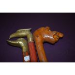 Three walking sticks, two with brass heads, one of an eagle the other of a duck and one with a