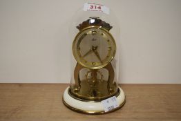An early 20th century anniversary Schatz & Sohne 8 day clock, raised on a circular base under a
