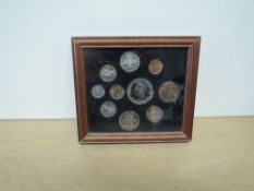 A 1951 Festival of Britain Ten Coin Set, farthing to five shilling, framed and glazed, appears to be