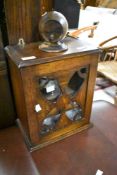 An early 20th Century oak smokers cabinet and accessories including treen string dispenser