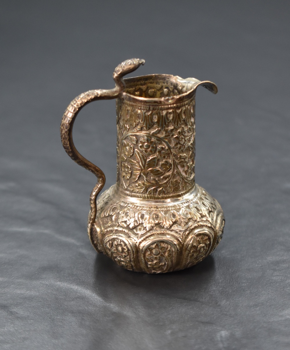 An Eastern white metal cream jug, of bulbous form having a narrow spout opposed by a handle in the - Image 2 of 3